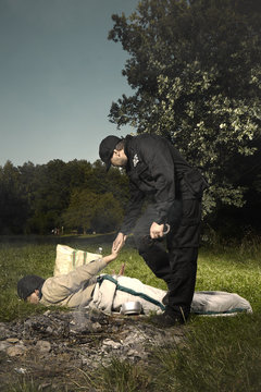 Young vagabond man sleeping in park catched by police patrol