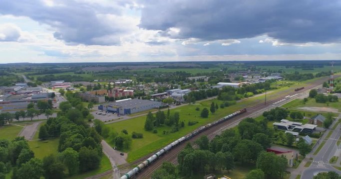 Train running over railway in the city at sunny day. Aerial view