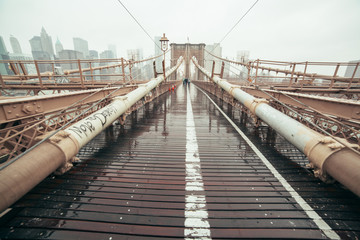 Brooklyn Bridge: Viewed down the center against NYC skyline on a rainy day