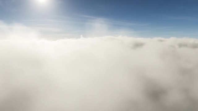 White fluffy clouds moving towards the camera that is positioned just a bit above them. The bright sun is shining in the background.