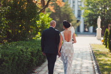Fototapeta premium Wedding couple on a walk bride and groom sea field sunset architecture grass sand