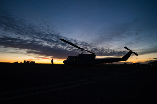 Silhouette of a UH1H Huey helicopter during sunset