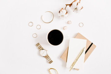 Fashion blog gold style desk with woman accessory collection: golden watches, scissors, coffee cup, notebook and cotton branch on white background. Flat lay. Top view.