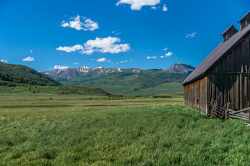 Fototapeta na wymiar Barn in meadow in high Rocky Mountains