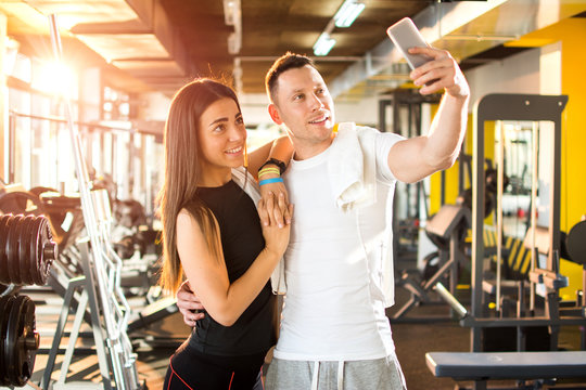 Young couple taking a selfie in gym.