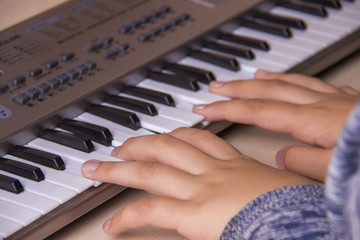 Obraz premium Beautiful girls hands playing electronic piano keyboards.