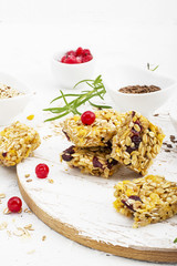 Cereal bars with red berries, honey for a healthy snack on a light background with flax seeds, sesame. Top View