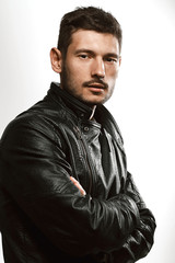 Fototapeta premium Fashionable male portrait in studio on a white background and in a leather jacket