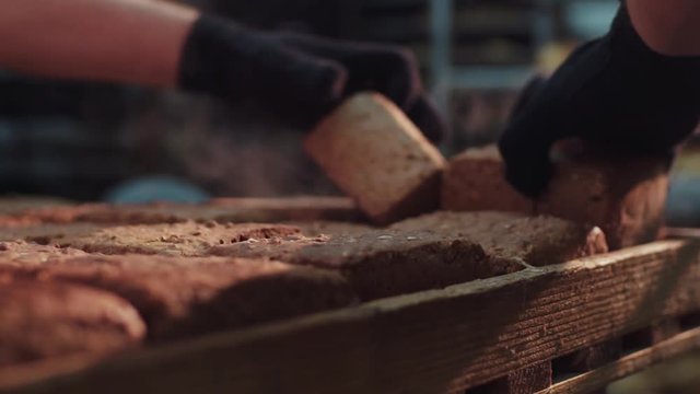Extreme close up view of steaming hot ready-made loaves of bread sorted by the baker. Bread manufacturing, industry. Beautiful view.