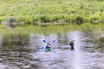 the river fishing boat floating past the man and
