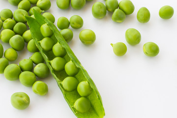Fototapeta na wymiar Green peas and pea pod closeup on white. Top view. Food background.