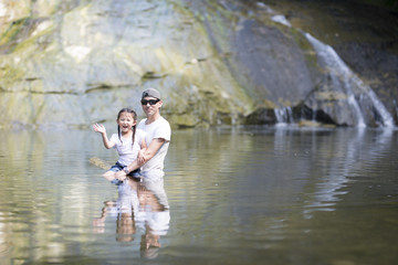 Father and daughter playing in the river