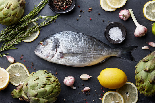 Fresh Raw Sea Bream Fish Cooking On Black Stone Countertop, Top View