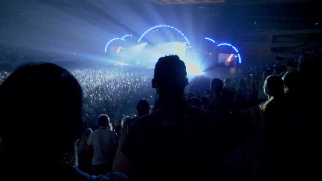 People dancing from the stands in concert in full pavilion