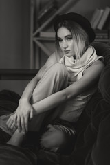 Portrait of young beautiful girl sitting on a sofa in cozy home environment