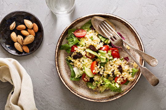 Warm salad with bulgur, vegetables and leaves