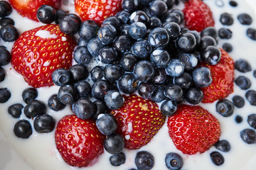 Strawberries, blueberries and milk in a white bowl