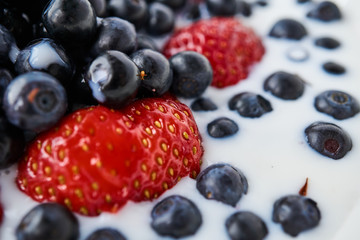 Strawberries, blueberries and milk in a white bowl