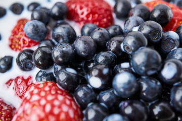 Strawberries, blueberries and milk in a white bowl