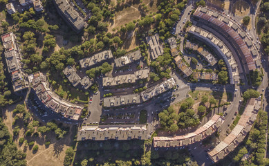 Vista aerea ortogonale di un quartiere periferico della città di Roma. Le costruzioni sono moderne e anche l'urbanistica è futuristica. Tanti sono gli alberi piantati intorno alle abitazioni.