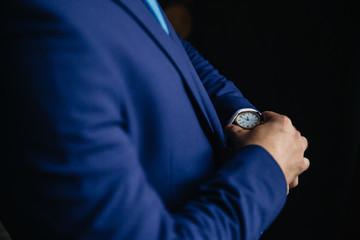 Businessman checking time on his wristwatch. men's hand with a watch.