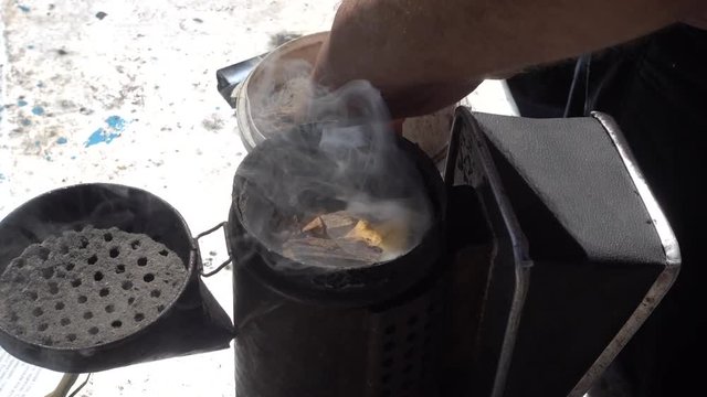 Open and smoke bee smoker. Cllose up top view footage.