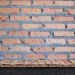 Empty wooden table with brick wall