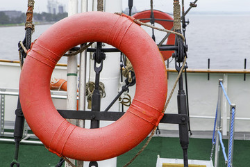 Red lifebuoy. Red life buoy with a rope on the ship.