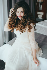 Luxury stylish bride sitting on the bed