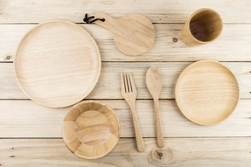 Set of wooden Kitchenware cutlery utensil (fork, spoon, bowl, plate) on wooden table with free copy space