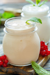 Obraz na płótnie Canvas Sour baked milk and yogurt in glass jars closeup.