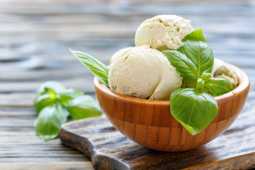 Basil homemade ice cream in a wooden bowl.