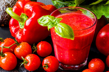 Fresh tomato detox smoothie in a glass on a black slate board. Close-up