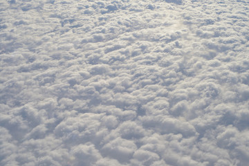Clouds from above.  Clouds pattern. Sky background. View of window at flying airplane and sky with clouds from top view. Cumulus. 