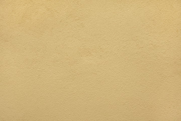 Yellow ochre painted stucco wall. Background texture