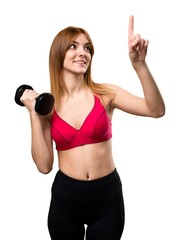 Beautiful sport woman with dumbbells touching on transparent screen