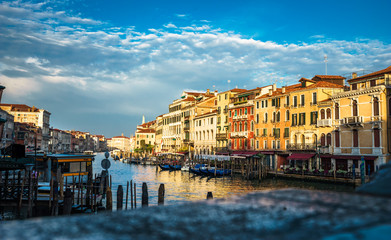 Panoramic view on famous Grand Canal among historic houses in Venice, Italy at sunrise. Picture took from the Rialto bridge with blurry foreground.