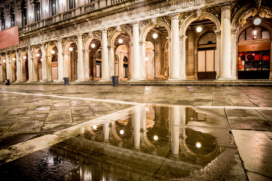 Night view of San Marco with reflecion in reflection in a puddle. Venice, Italy