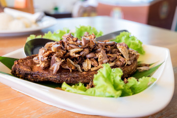 Fried fish topped with garlic served on white dish