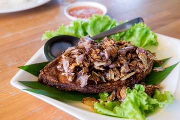 Thai food cuisine - Fried fish topped with garlic served on white dish