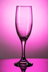 Empty champagne glass on a lumen on a purple background