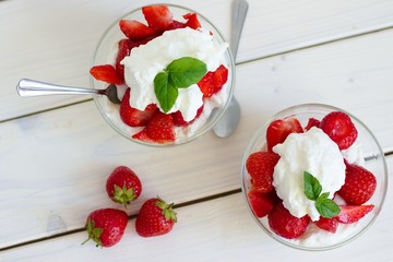 Glass bowl of strawberries with whipped cream. Traditional snack at famous lawn tennis tournament.