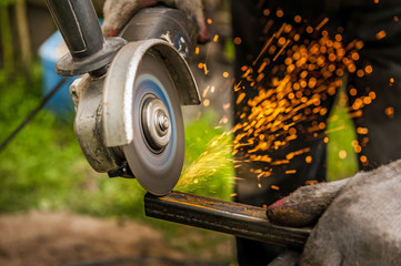 Man grinding metal at his backyard