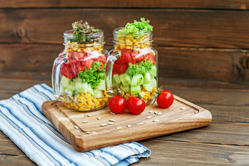 Vegetable salad in glass jars. Cucumbers, tomatoes and corn. Healthy food, Diet, Detox, Clean Eating or Vegetarian concept
