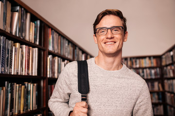 Young college student standing in library