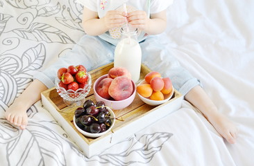 Obraz na płótnie Canvas Little Girl Eating Breakfast at Home Milk Berries Peaches Apricots Cherry Strawberry Yogurt Diet Vitamins Summer Concept of Healthy Food for Children