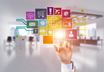 Modern office interior and close of businesswoman hand choosing icon on multimedia interface