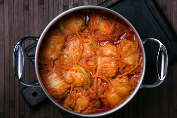 Cabbage rolls in tomato-cream sauce. A large saucepan with stuffed cabbage. Top view.