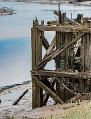 Fototapeta na wymiar Decaying wooden structure next to river