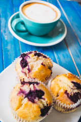 Blueberry cake with hot latte or capucino coffee in  blue club on blue vintage wooden table background
